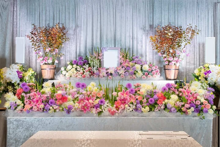 葬儀の花祭壇　紫とピンク色で淡く綺麗に仕上がっています。