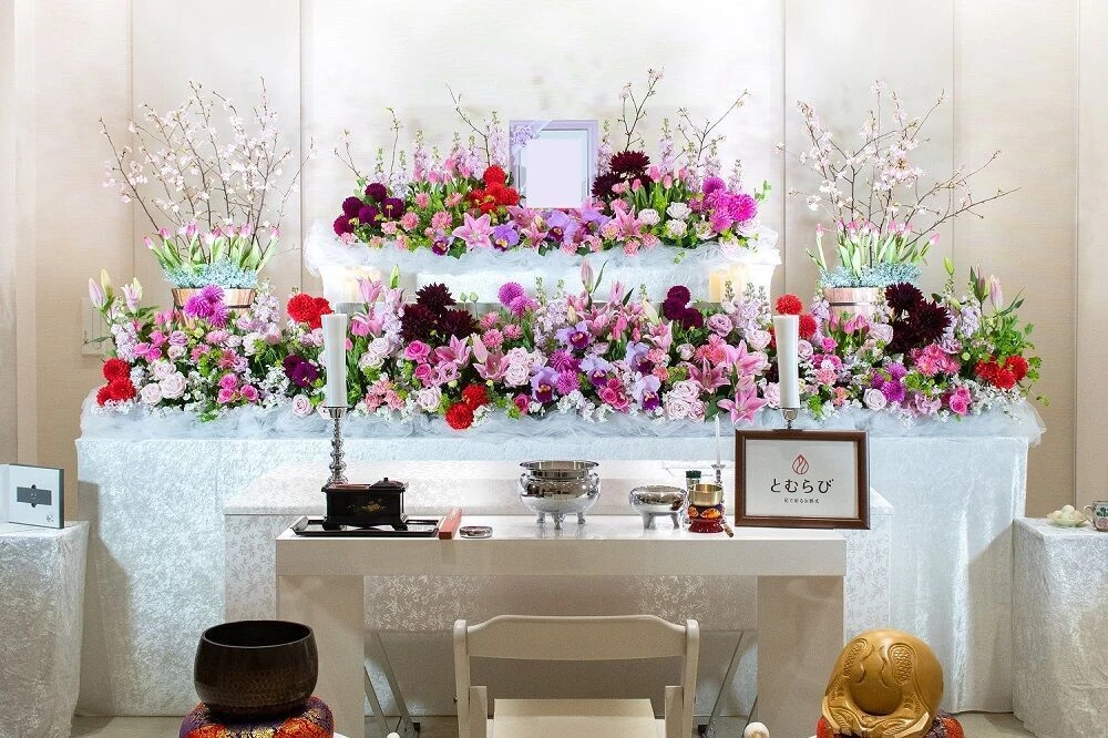 葬儀の花祭壇　ピンクや赤など使用しています